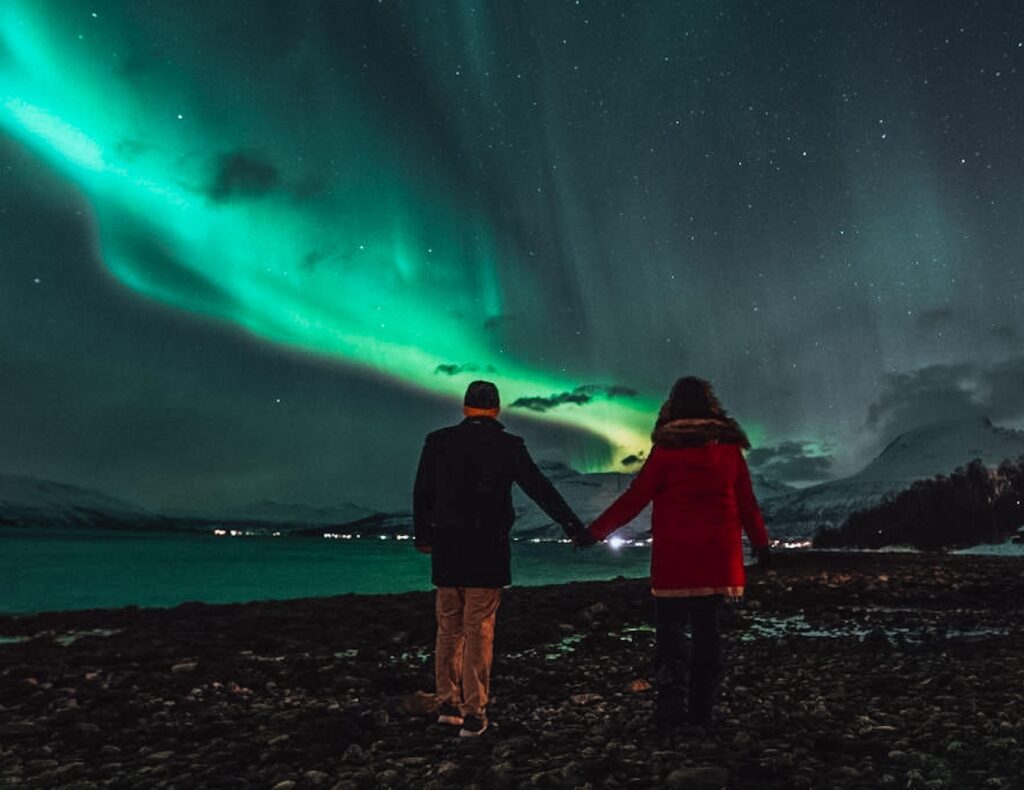 Couple holding hands during a northern lights tour
