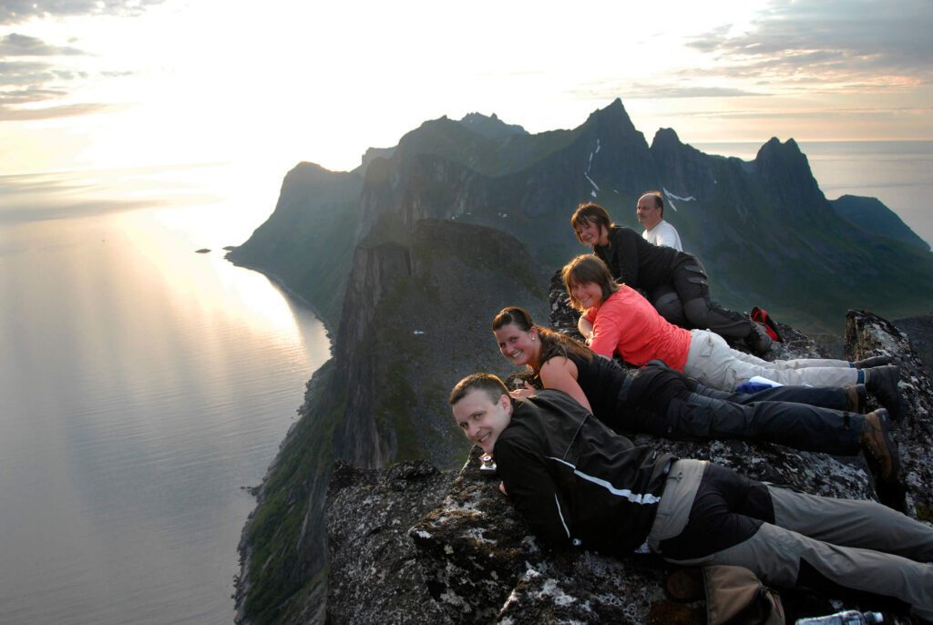 Hikers lying on the cliff on a mountain in Senja, Norway