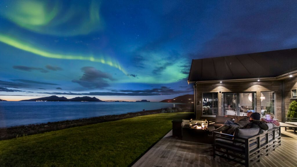 people watching the aurora from the terrace overlooking the fjord