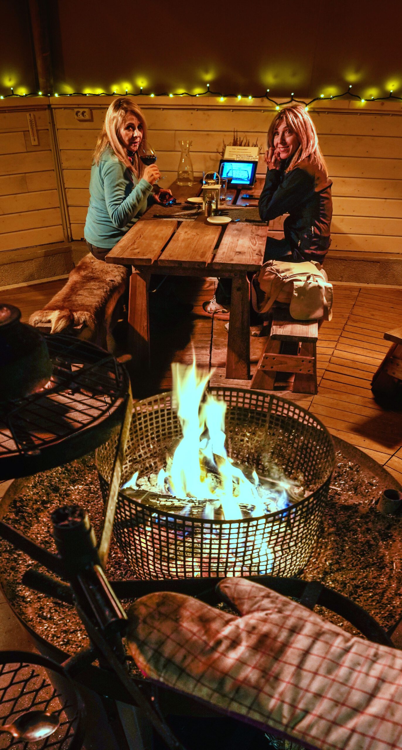 Two women sitting in lavvo around fire