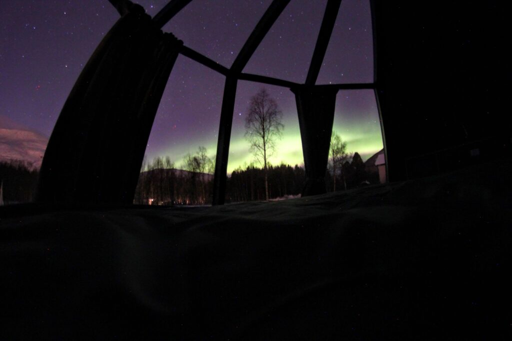 View of the Northern Lights from the inside of the Aurora hut