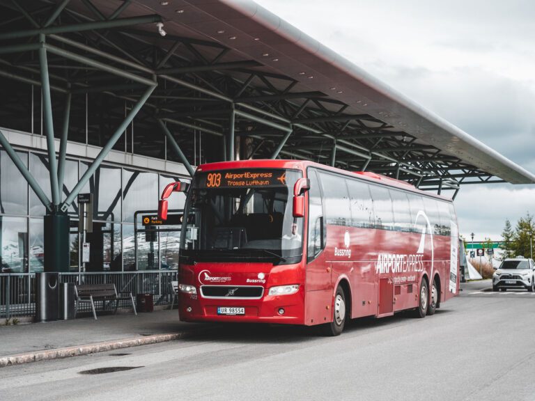 Picture of a red bus taken in from of Tromsø Airport of the Airport Express bus