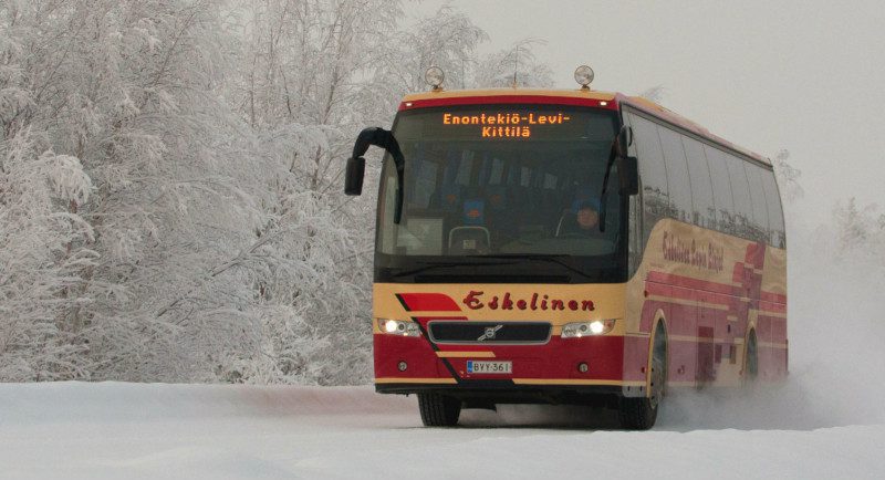 The Finnish bus company Eskelisen on the road surrounded by snow