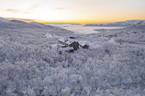 Aerial picture of the Cahkal Hotel in the winter. With the snowy forest in the background.