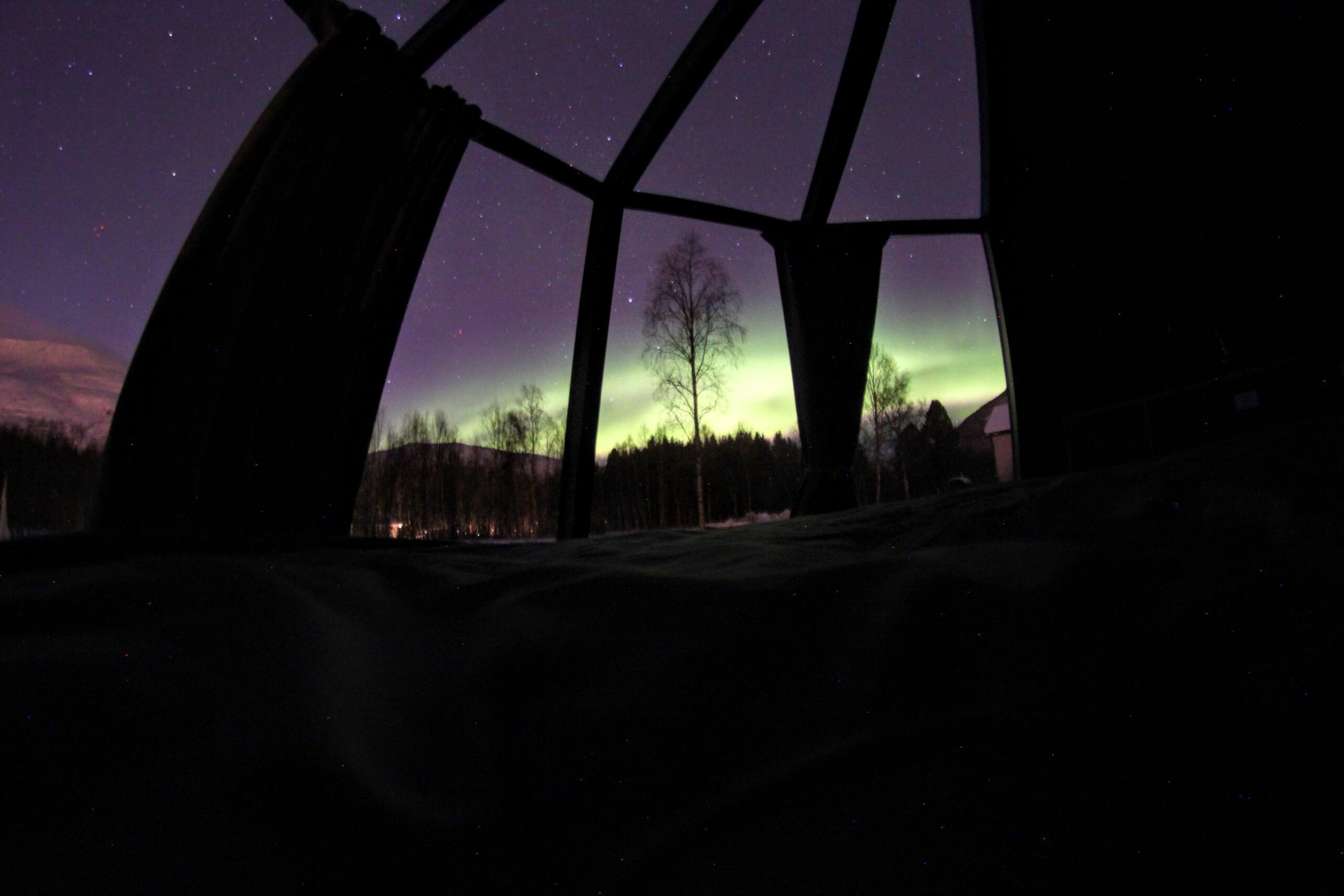 The view outside the aurora hut, a glass view of Northern Lights in the night
