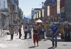 many people enjoy the sun in the main street of Tromsø in the summer
