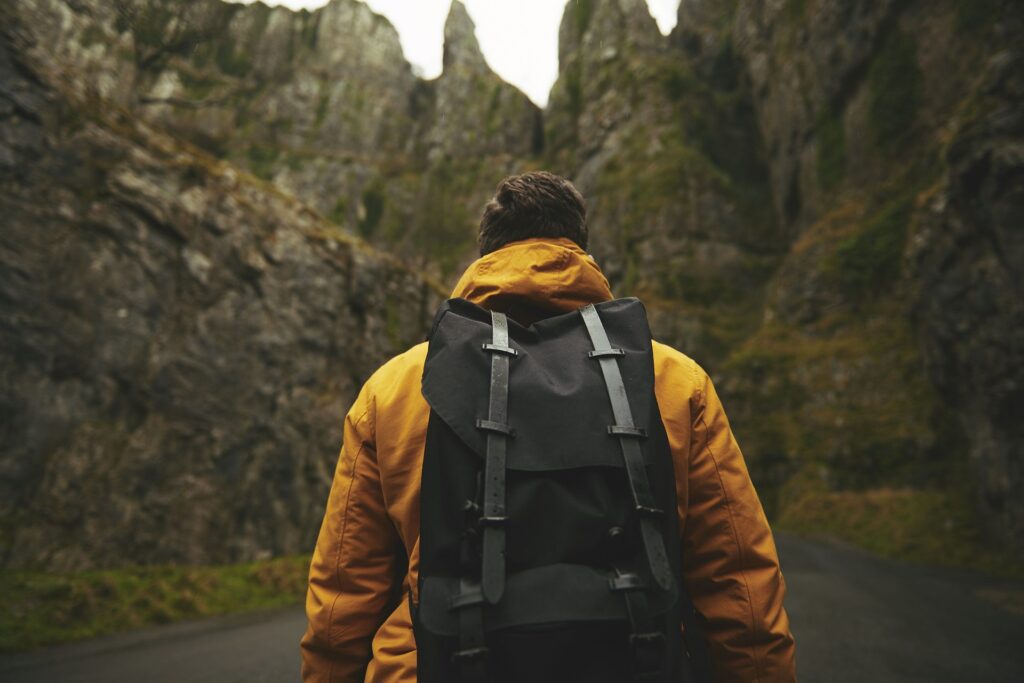 man from the back with a backpack on a hike