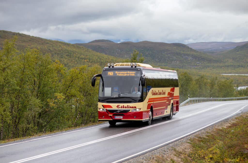 Eskelinen bus driving along a summer road in northern Norway as a part of the Arctic Route journey.