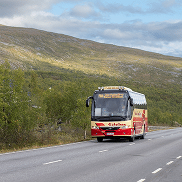 Eskelinen bus driving along a summer road in northern Norway as a part of the Arctic Route