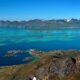 Clear blue waters with green mountains in the background in Senja, northern Norway.
