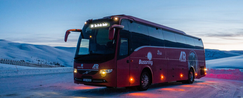 Red bus parked between Tromsø-Storslett, Norway