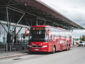 Red Airport Express bus parked outside Tromsø Airport in Norway.