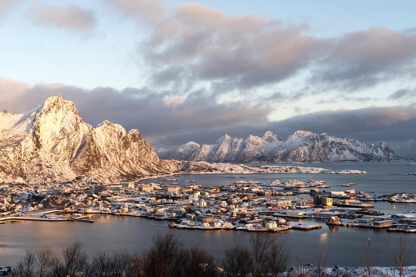 Svolvær harbor in Lofoten with snow-covered mountains at sunset in Northern Norway