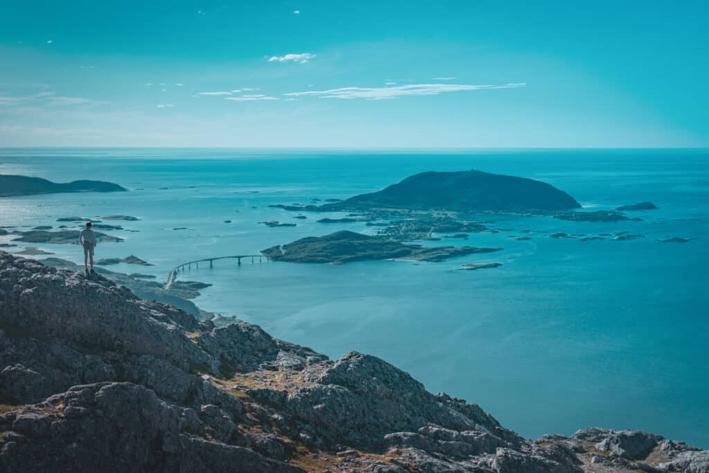 A person admiring the view of Sommarøy island while hiking during a beautiful summer day