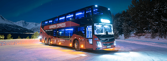 Aurora Express double-deck red bus from Best Arctic stopped on a snowy road at night