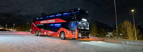 Aurora Express double-deck red bus from Best Arctic stopped on a snowy road at night