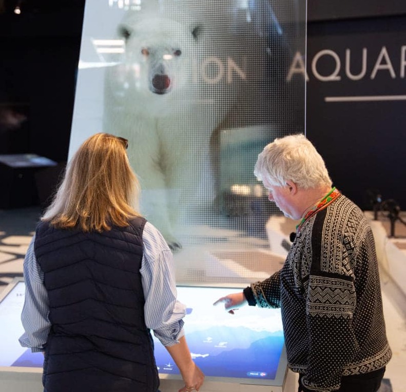 Visitors exploring an interactive Arctic exhibition at Polaria in Tromsø, Northern Norway